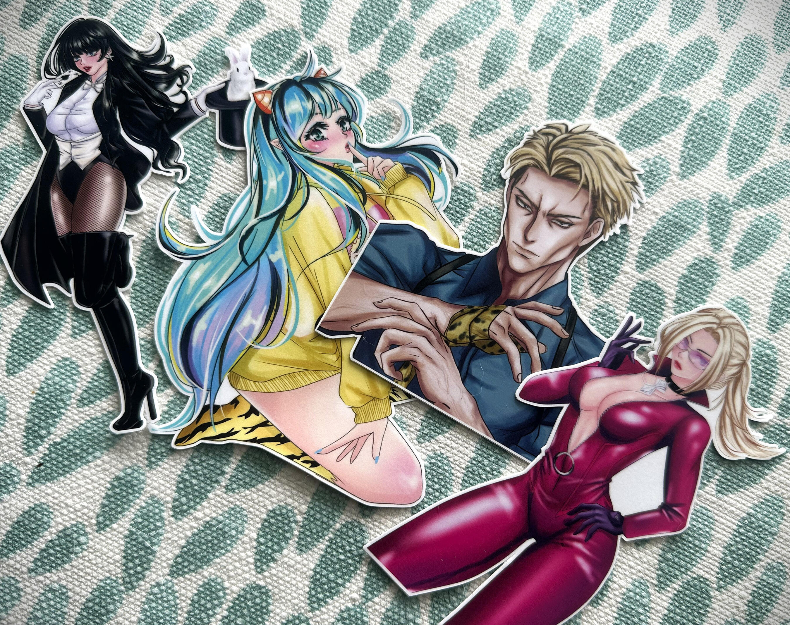 anime sticker collection Four anime‑style character stickers displayed on a textured green fabric background.
