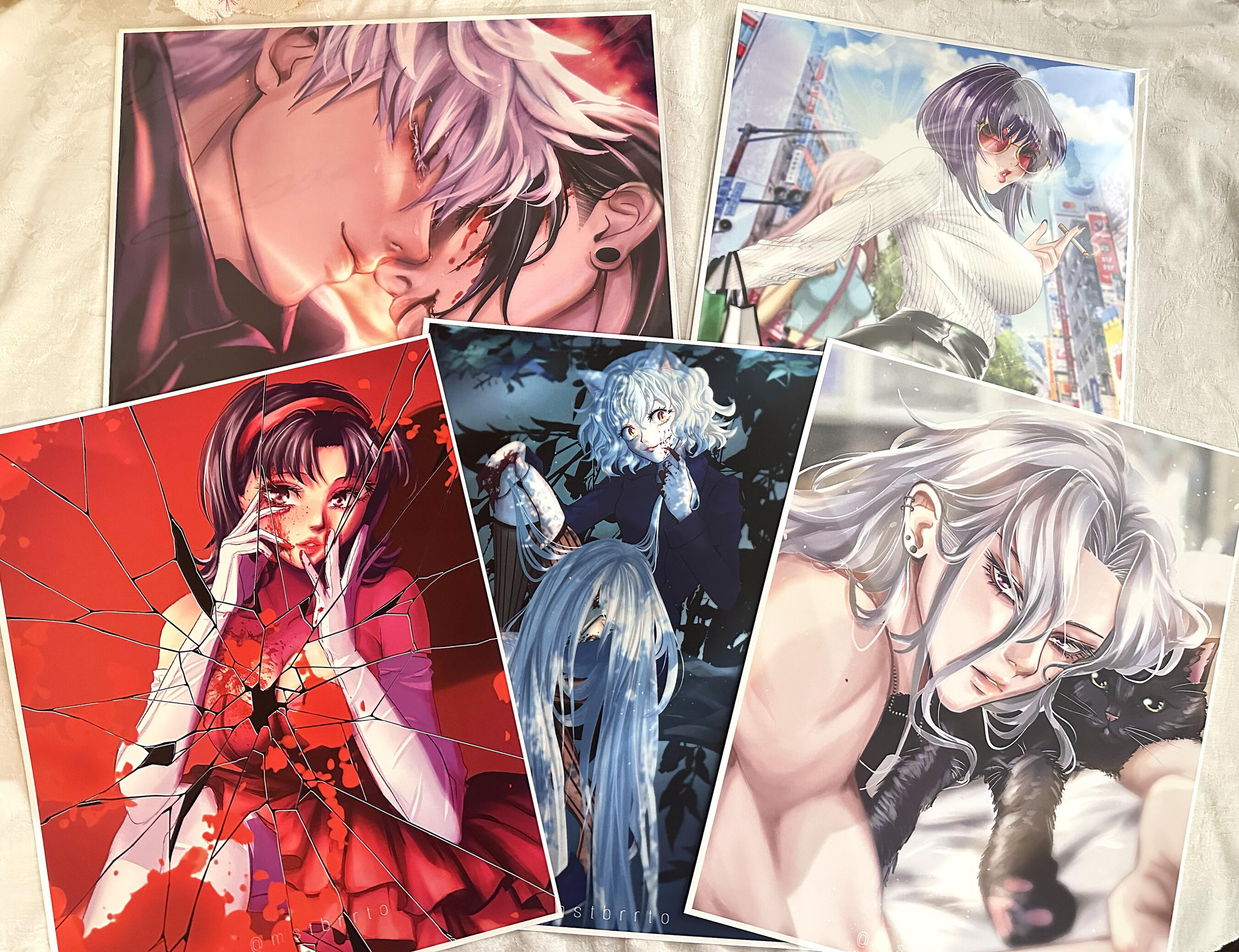 Five 11×14 anime‑inspired art prints featuring expressive characters and detailed colorwork displayed on a light fabric background.
